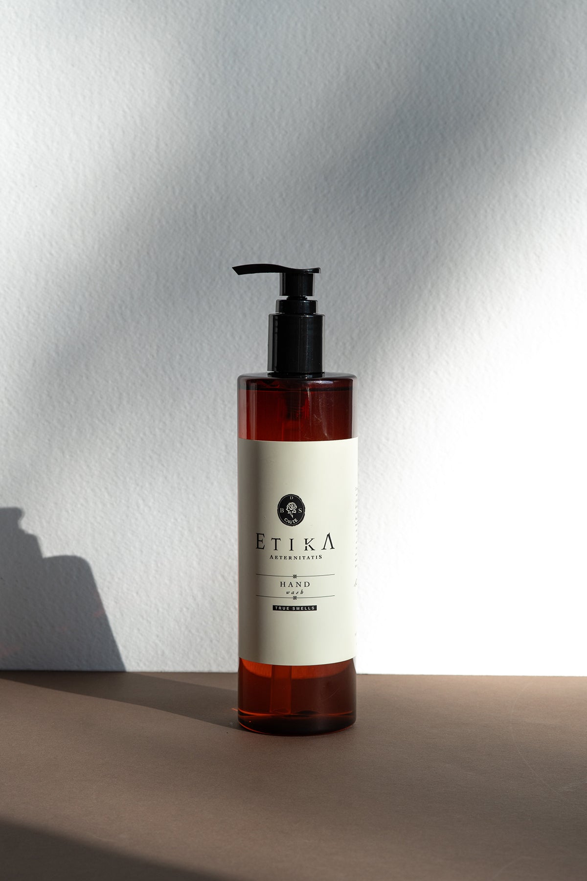 Bottle of Etika hand wash on a neutral background